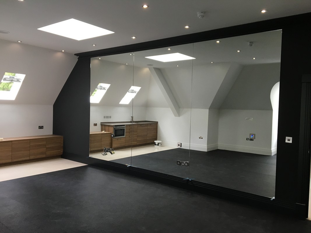 Frameless glass wall dividing loft conversion in Kensington
