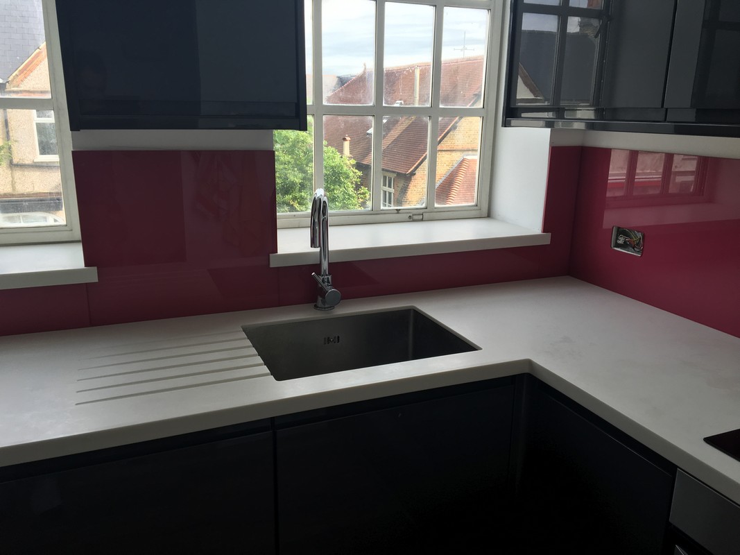 Deep plum coloured glass splashback in modern Kensington kitchen